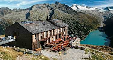 Die Olpererhütte besitzt einen Logenplatz über dem Schlegeis-Stausee. Dahinter Greinerkamm und der vergletscherte Möseler.