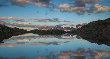 Ein schwarzes Dolomitenpanorama spiegelt sich im Schwarzen See.