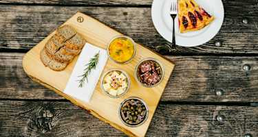 Die Chamanna Cluozza auf 1.882 Meter Seehöhe (oben) ist die einzige bewirtschaftete Hütte im Schweizerischen Nationalpark. Dort werden Nachhaltigkeit und Regionalität vor allem seit dem Umbau vor drei Jahren sehr ernst genommen: Das gilt für natürliche Baumaterialien wie Kalk und Stampflehm, die 30.000 Lärchenschindeln – und die Zutaten für die Speisen, etwa Alpentapas und Zwetschkenkuchen (unten).