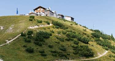 Oberhalb von Garmisch-Partenkirchen auf dem Gipfel des Wank im Estergebirge steht das Wankhaus direkt neben dem Gipfelkreuz.