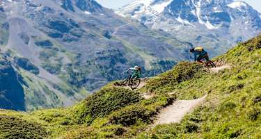 Mountainbiker auf dem Corviglia Flow Trail mit Blick auf den Piz Corvatsch (3.451 m)