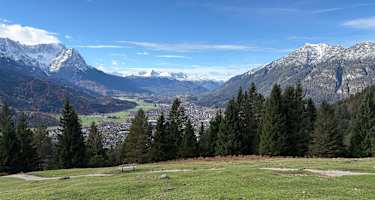 Von der Eckenhütte genießt man einen wunderschönen Ausblick auf Garmisch-Partenkirchen und links das Zugspitzmassiv.