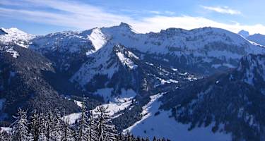 Der Hohe Ifen als Zacken in der Bildmitte. Die Abfahrt verläuft nach links dem Grat entlang und dann abwärts in die sonnenbeschienen Hänge