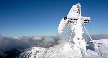 Das oft stark rauhreifüberzogene Gipfelkreuz auf der Hohen Veitsch, hinten links der Ötscher