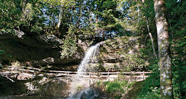 Unter dem kleinsten der drei Wasserfälle führt ein Weg entlang.