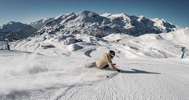 Ein Skifahrer carvt in hohem Tempo über die Pisten von Obertauern.
