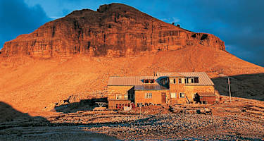Piz Boè und Boèhütte glühen im Abendlicht.