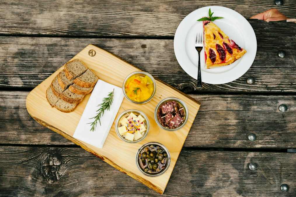 Die Chamanna Cluozza auf 1.882 Meter Seehöhe (oben) ist die einzige bewirtschaftete Hütte im Schweizerischen Nationalpark. Dort werden Nachhaltigkeit und Regionalität vor allem seit dem Umbau vor drei Jahren sehr ernst genommen: Das gilt für natürliche Baumaterialien wie Kalk und Stampflehm, die 30.000 Lärchenschindeln – und die Zutaten für die Speisen, etwa Alpentapas und Zwetschkenkuchen (unten).