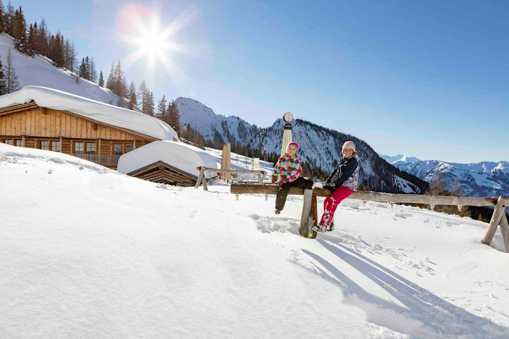 Kinder vor der tief verschneiten Loosbühelalm