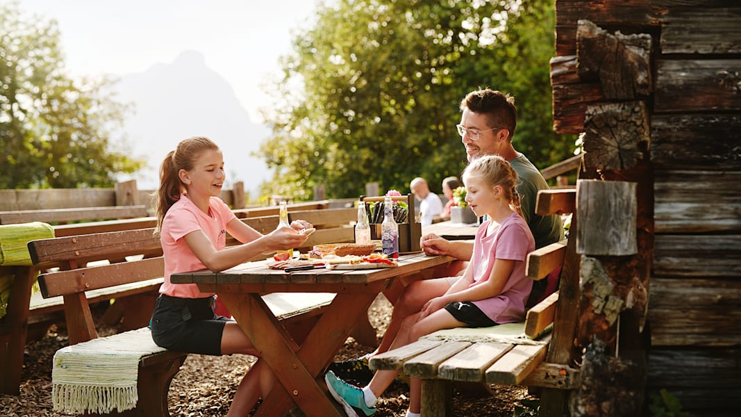 Ein Vater isst mit seinen zwei Töchtern regionale Gerichte der Region in der Steiermark.