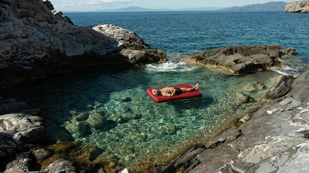 mann auf megamat von exped im wasser