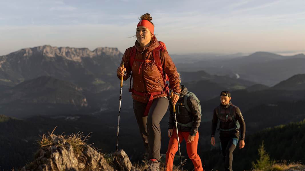 Eine Frau und zwei Männer wandern einen Berg in Berchtesgaden hinauf.