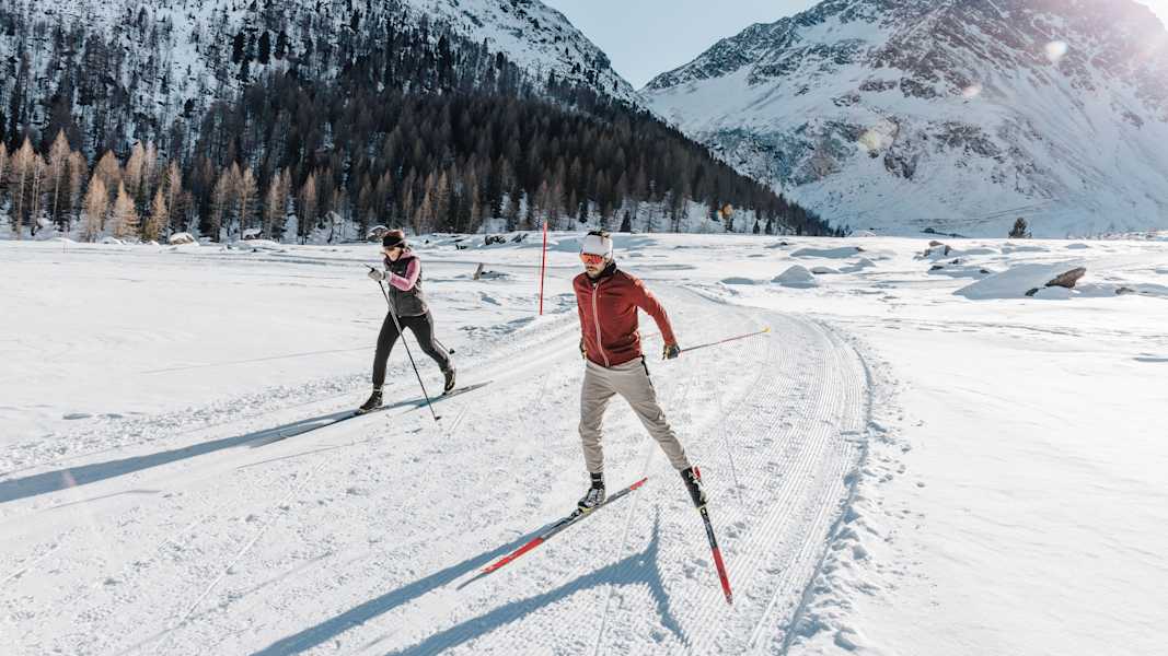 Auf perfekt gespurten Loipen gleitet man durch verschneite Wälder und weite Täler.