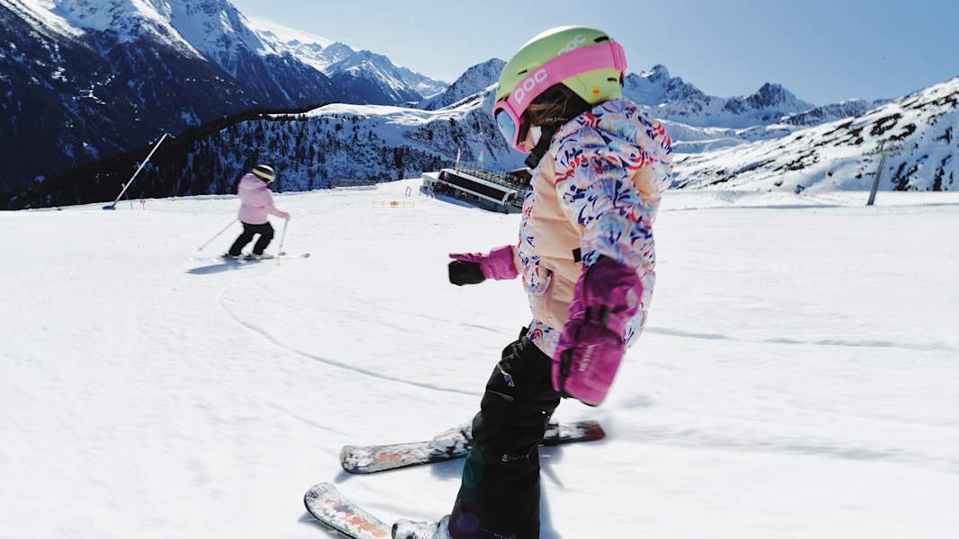 Ein Mädchen fährt mit seinen kleinen Skiern im Pflug die Piste in Kappl hinab.