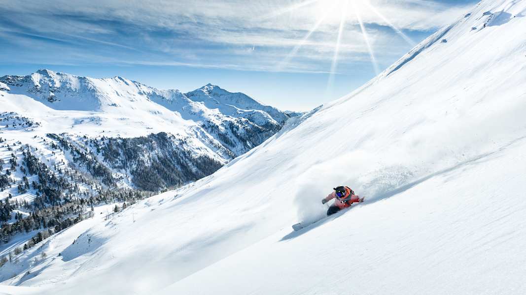 Ein Skifahrer fährt durch die unberührte Schneelandschaft.