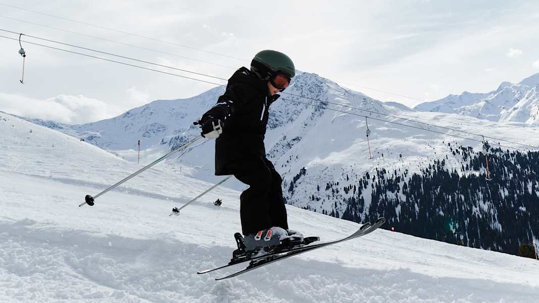 Ein kleiner Junge fährt den Hang in See im Paznaun mit seinen Skiern hinunter.