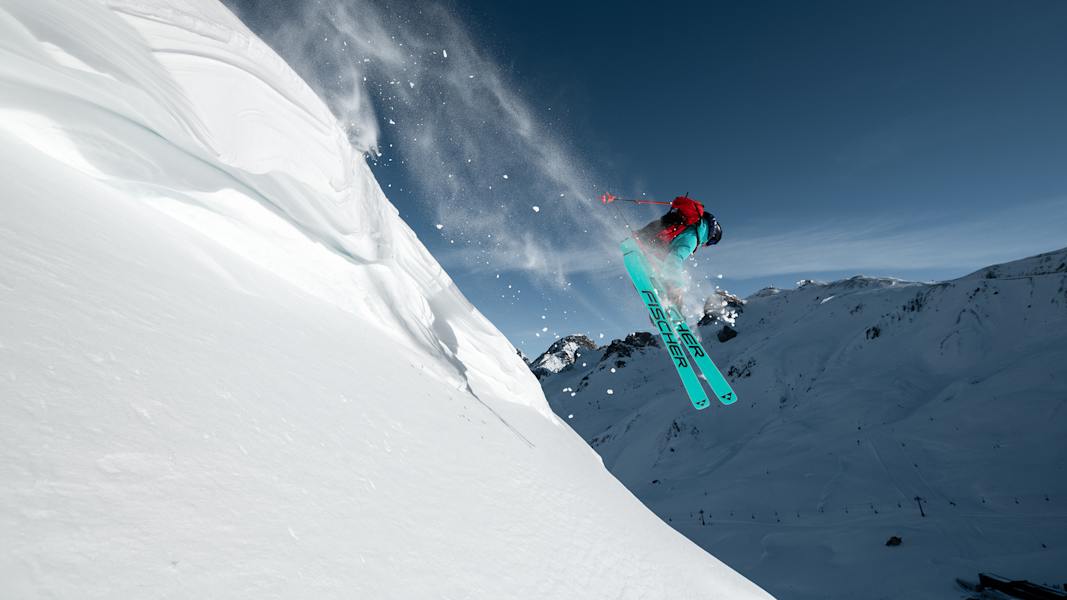 Ein Freerider fährt einen unberührten Hang hinunter.