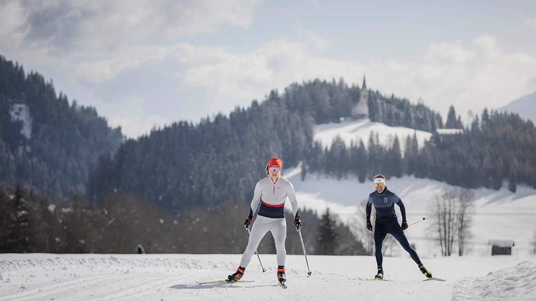 Frau und Mann beim Langlaufen in Ratschings auf einer Loipe mit Ausblick.