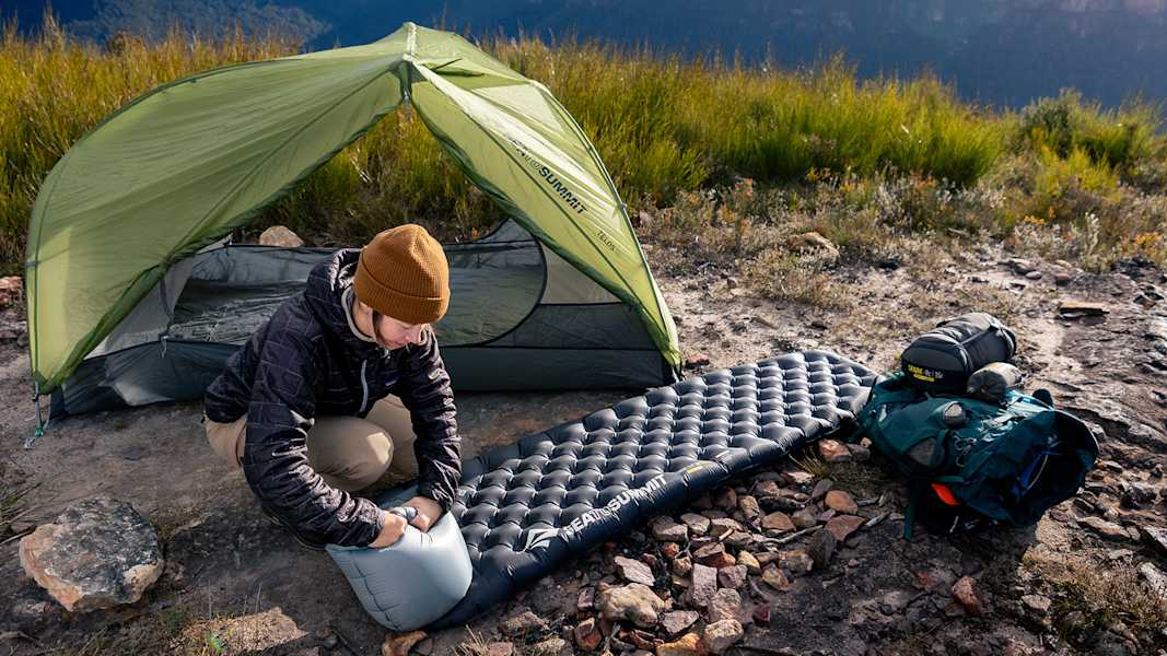 Camperin richtet Sea to Summit Ether Light XR Isomatte neben Zelt ein – ultraleichte Campingausrüstung für Komfort in den Bergen