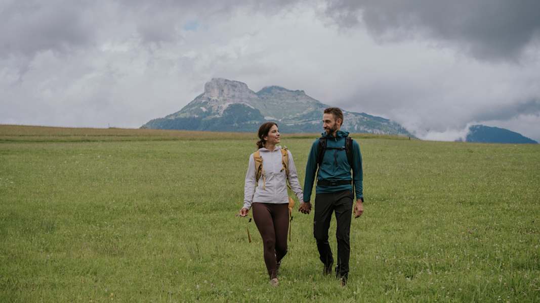 Zwei Wanderer auf einer Almwiese im Salzkammergut, im Hintergrund sieht man den Loser.