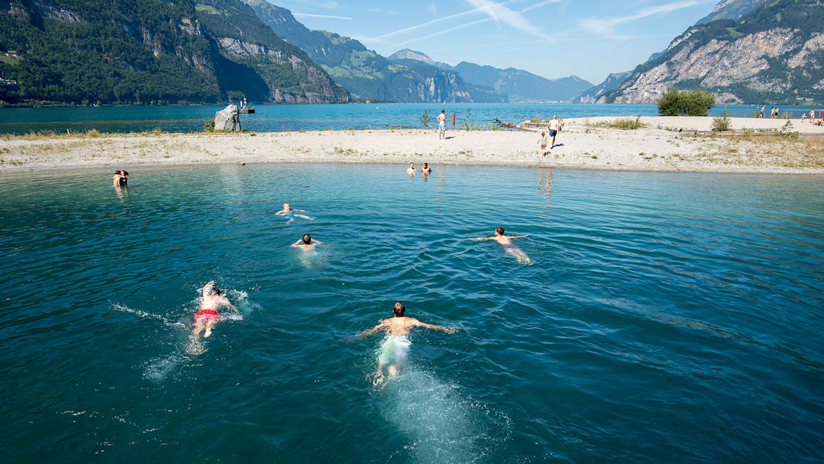 Eine Gruppe von Personen schwimmen in einem blauen See.
