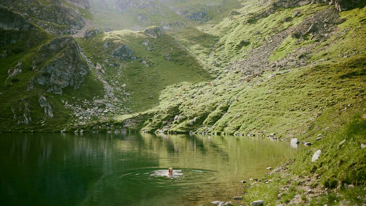 Bergsee Person schwimmt