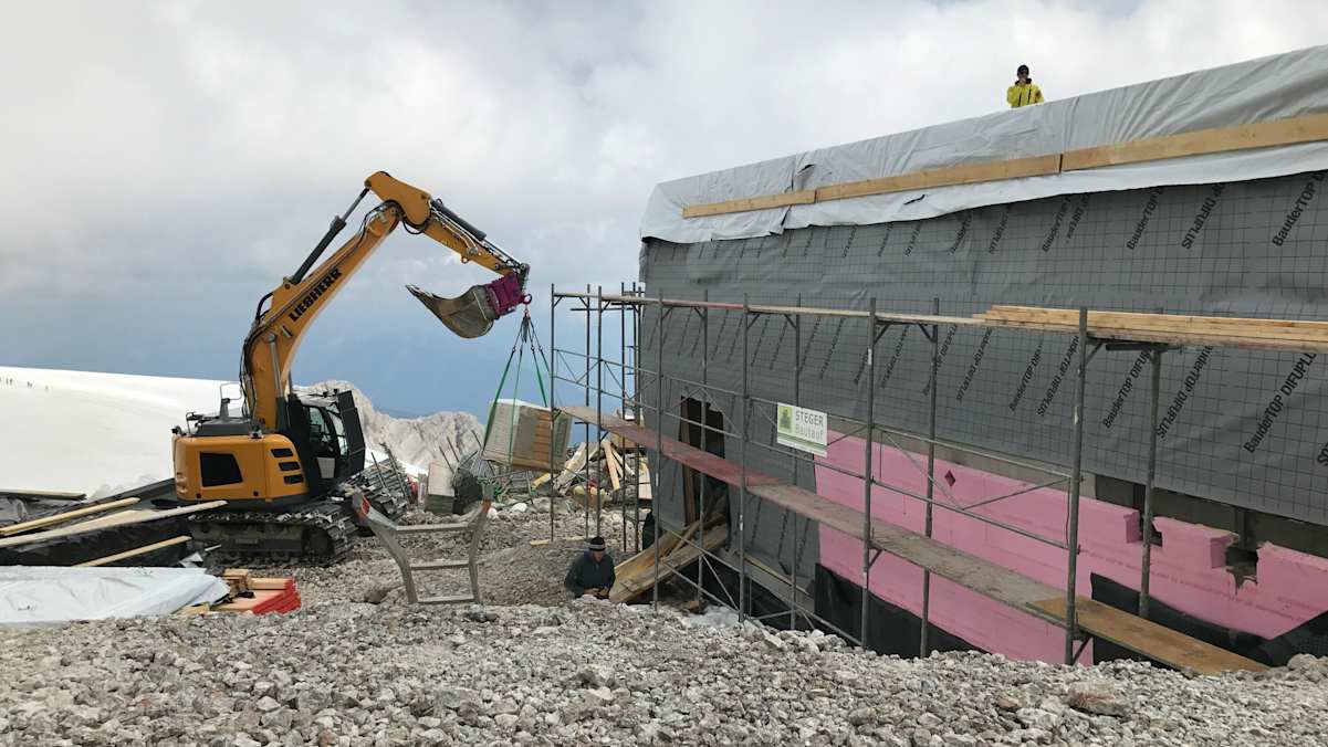 Immer wieder muss der unfertige Holzbau aufgrund schlechten Wetters eingepackt werden.