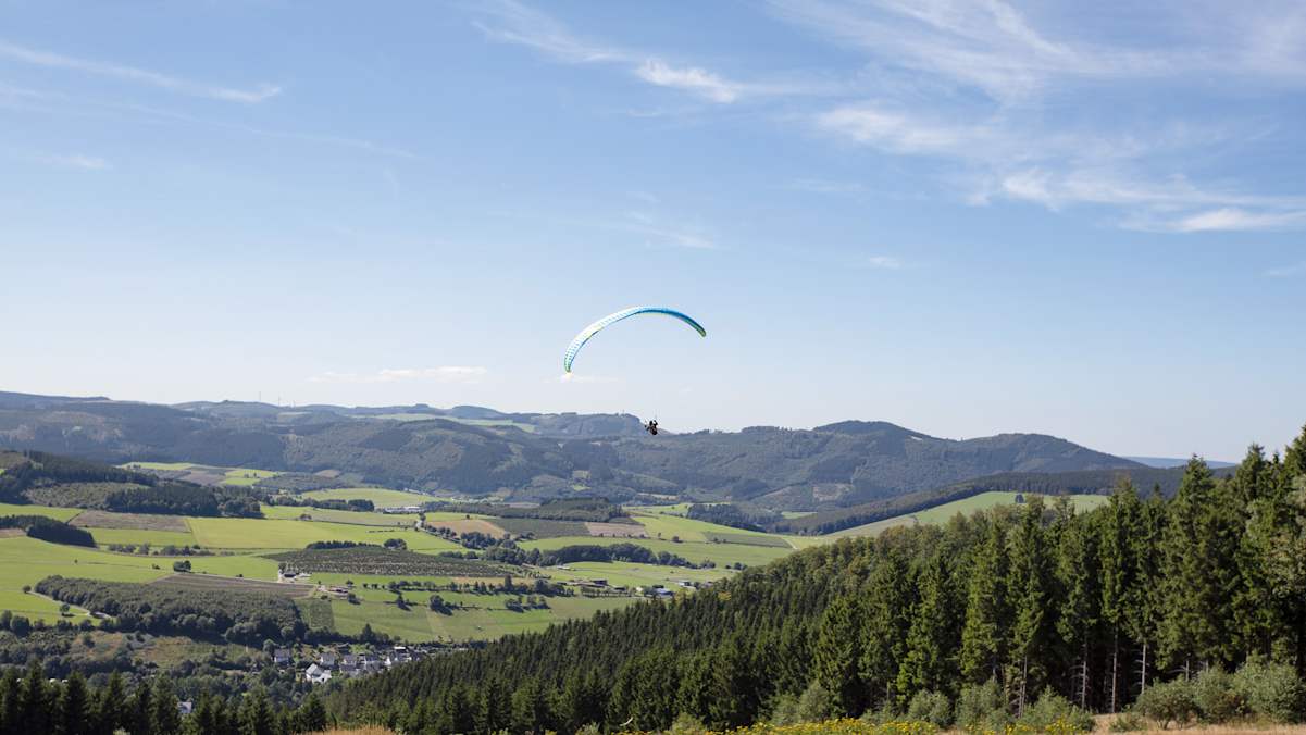 Ein Gleitschirmflieger startet vom Istenberg.