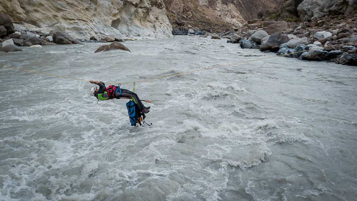 Arian überquert die starke Strömung mit Hilfe der von uns installierten Seilrutsche.
