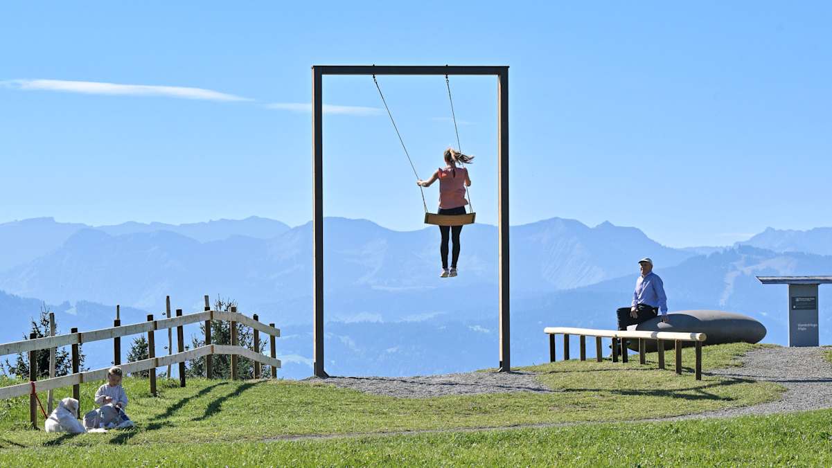 Eine Frau schaukelt auf einem Berg.