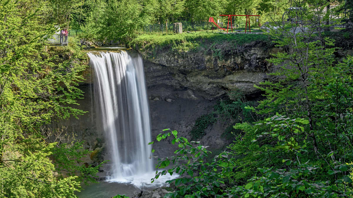 Zwei Menschen schauen auf einen großen Wasserfall