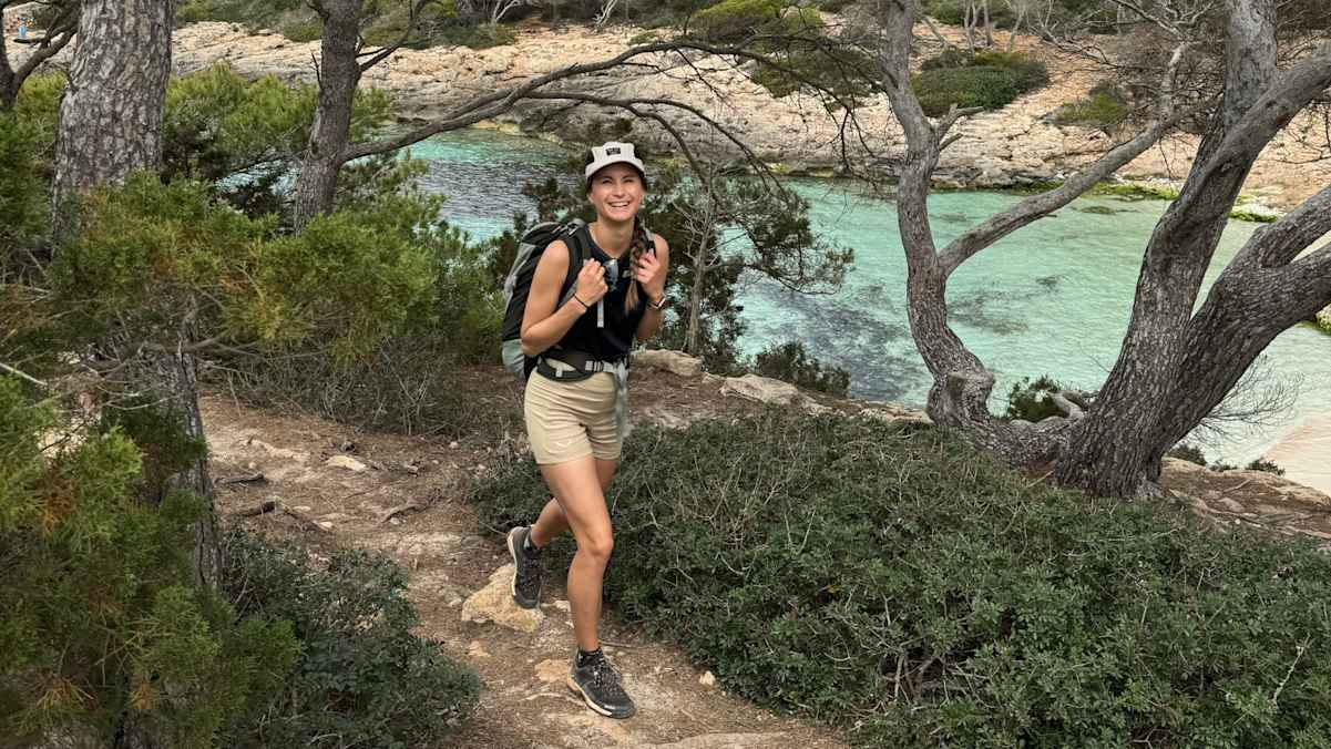 Die abwechslungsreiche Landschaft des Camí de Cavalls und die funktionale Trekking-Bekleidung von Salewa sorgen unterwegs für gute Laune. Immer auf Heidis Kopf: Die Hemp Flex 5 Panel Cap als luftiger Schutz gegen die Sonne.