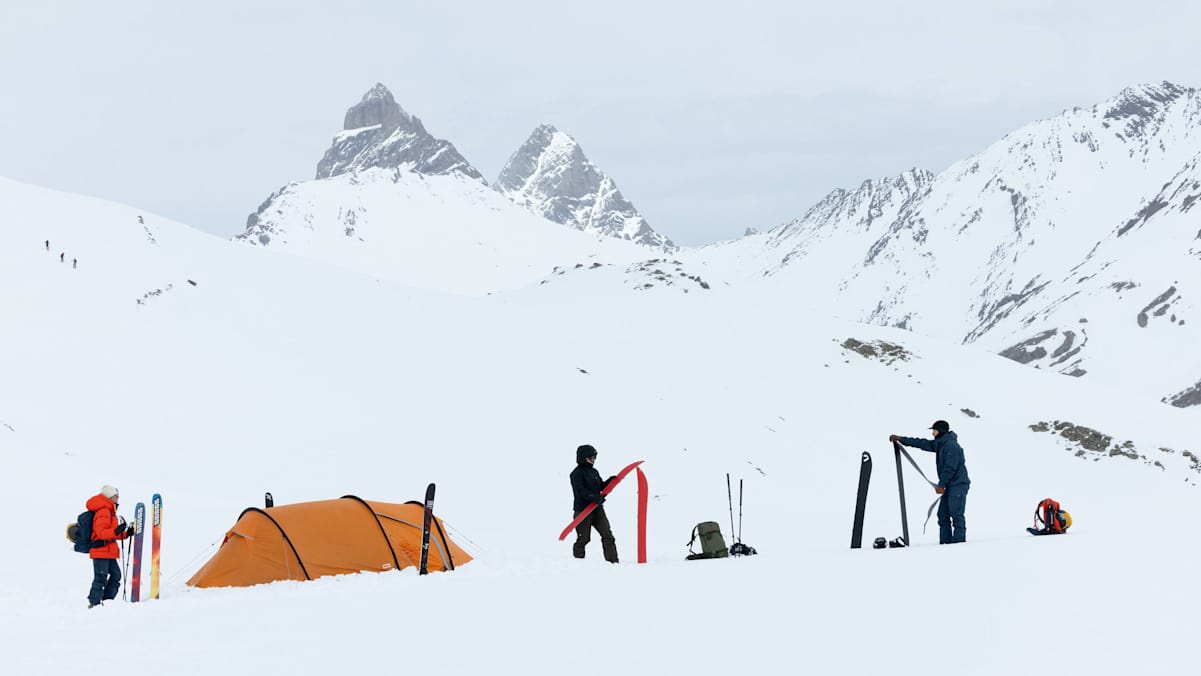 Drei Personen sind mit der neuen Bertagen-Kollektion von Fjällräven ausgerüstest und bereiten ihre Skitouren-Ausrüstung auf.