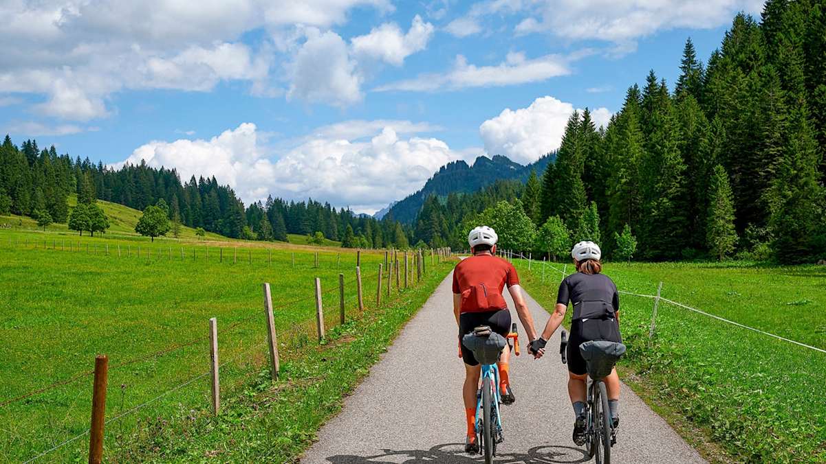 Zwei Radfahrer halten sich die Hände während der Tour.