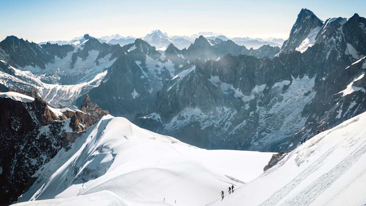 Drei Bergsteiger und ein atemberaubendes Panorama.