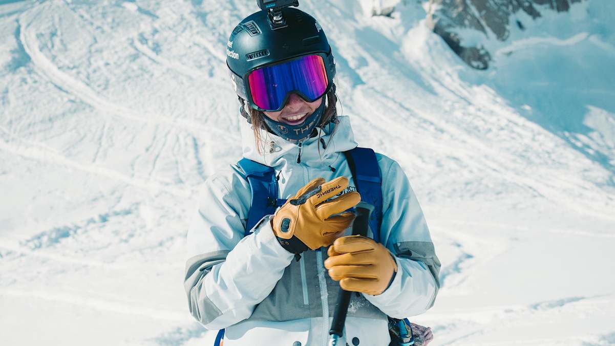Freeriderin mit Therm-ic Freeride Ultra Heat Lederhandschuhen beim Skifahren in verschneiter Berglandschaft – beheizbare Handschuhe für extreme Wetterbedingungen.