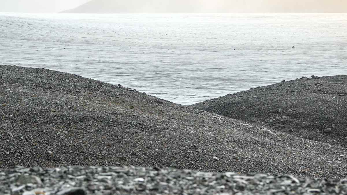 Der Skálafellsjökull am nebligen Horizont mit dunklen Kiesstränden und Meer im Vordergrund