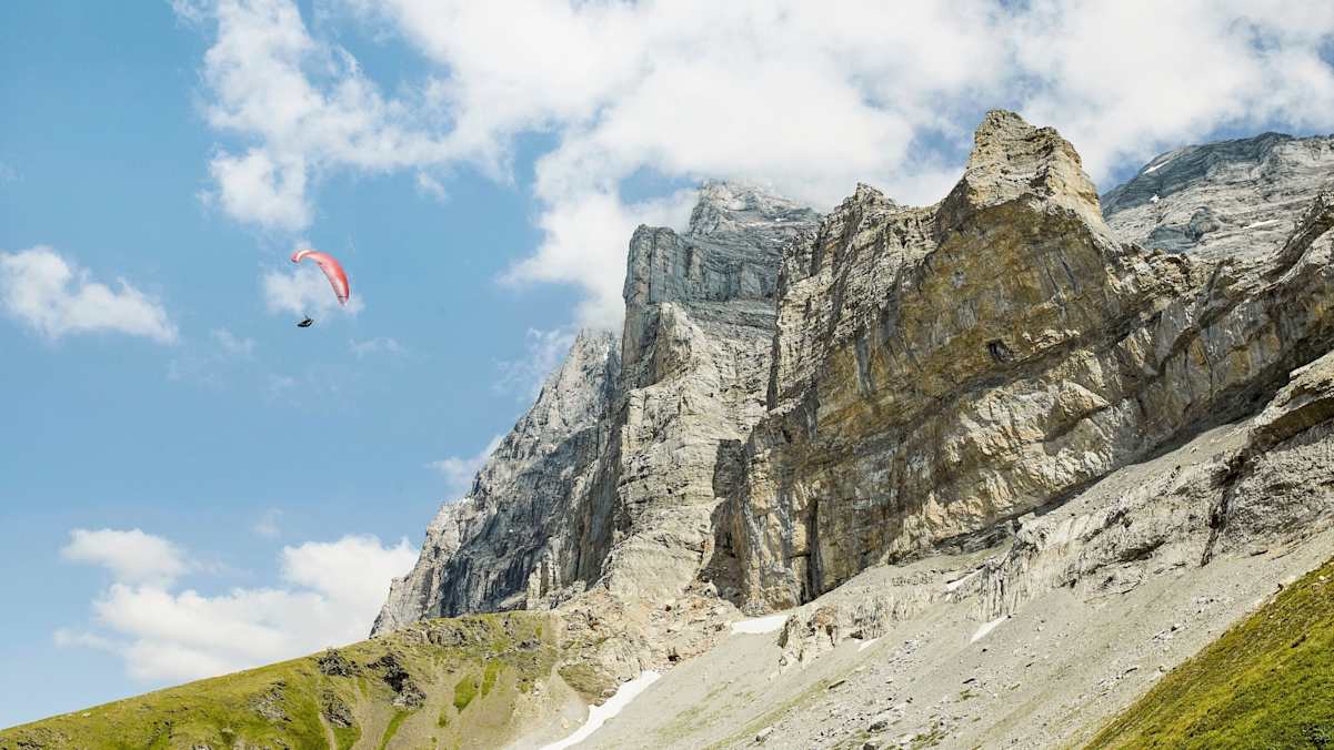 Ein Sportler mit einem Paragleiter in der Luft.