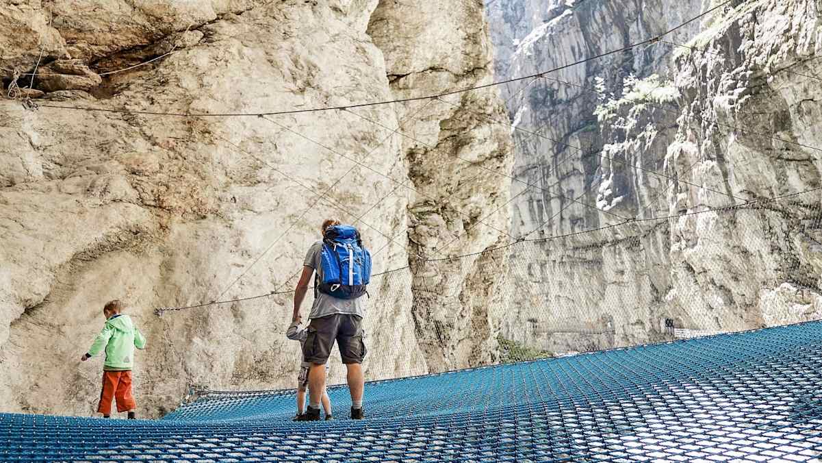 Wanderer beim überqueren eines Flusses.