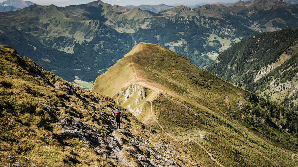 Ein Wanderer vor wunderschönem Bergpanorama.