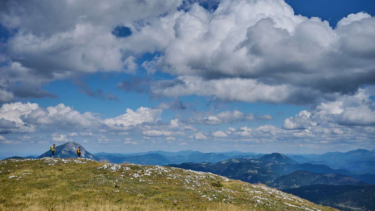 zwei Wanderer auf dem Weg zum Dürrenstein im Mostviertel, bewölkter HImmel und Berglandschaft