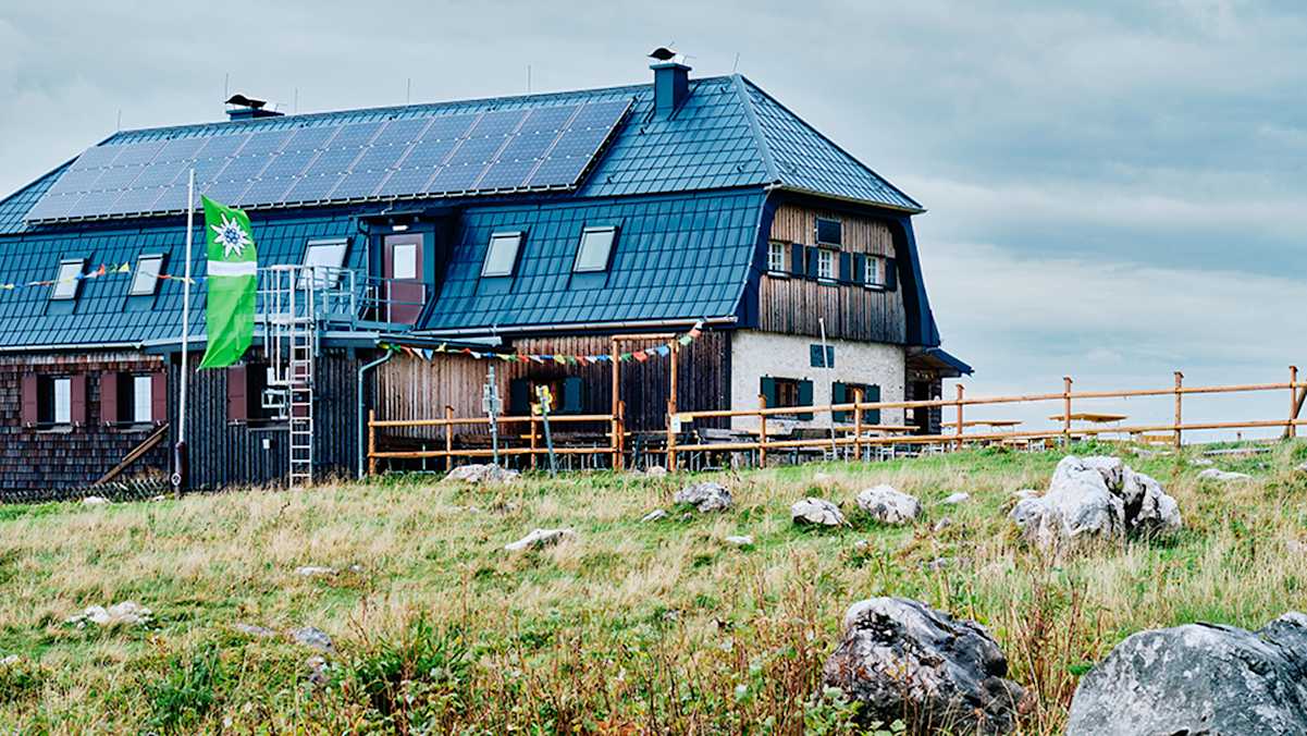 Hochleckenhaus in Oberösterreich; Berghütte mit Alpenvereinsfahne und Gebetsflagge vor dem Haus