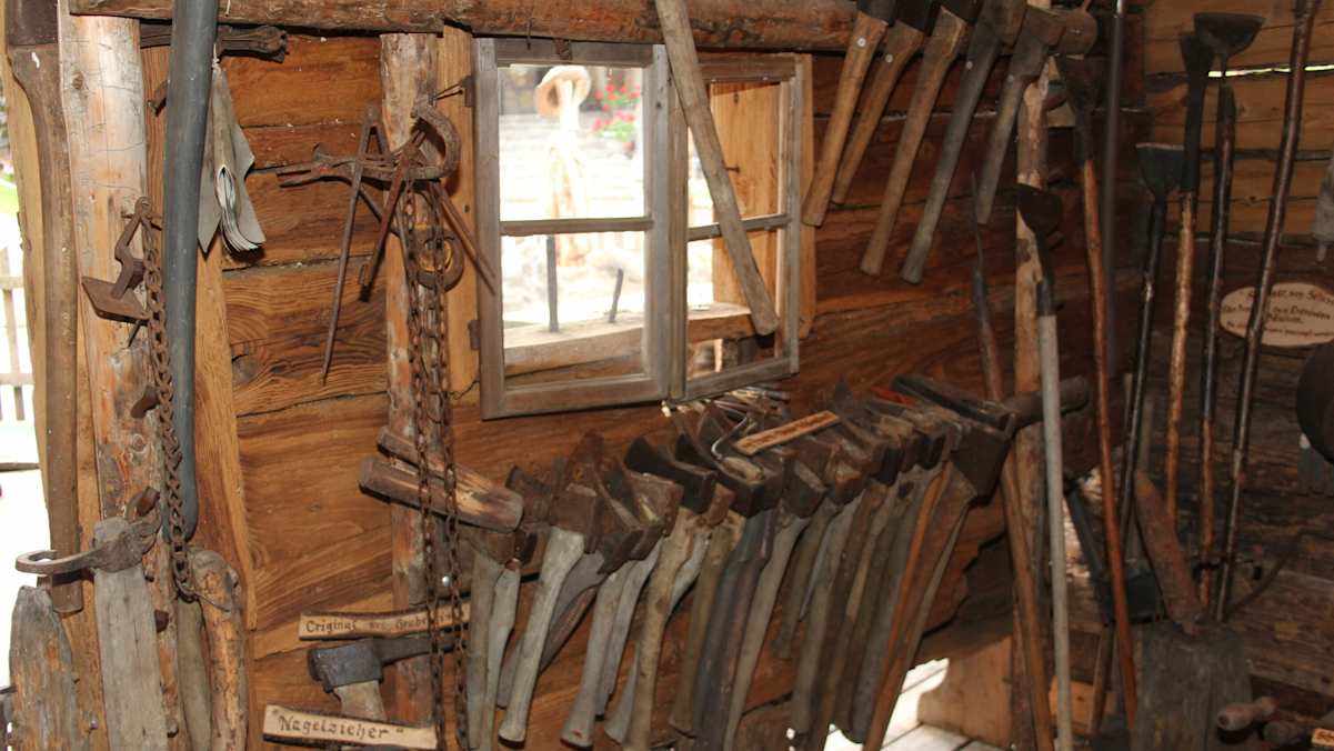 Alte Äxte hängen an einer Wand im Holzmuseum.