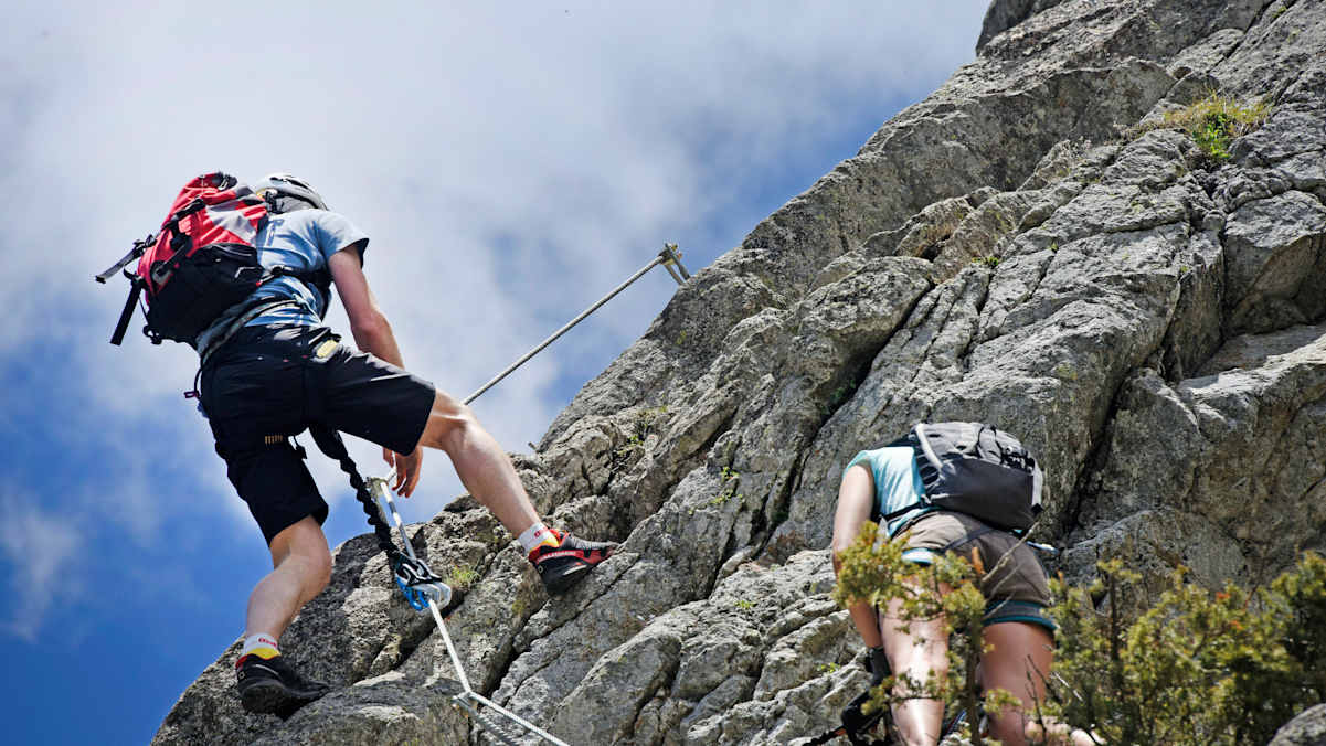 Mann im Klettersteigset an Falswand vom Kleinen Ifinger