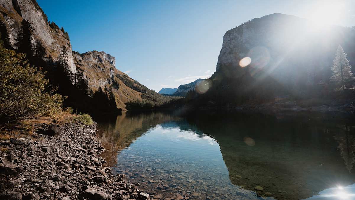 Der vordere Lahngangsee im Licht der Herbstsonne, flankiert von steil aufragenden Gipfeln des Toten Gebirges.