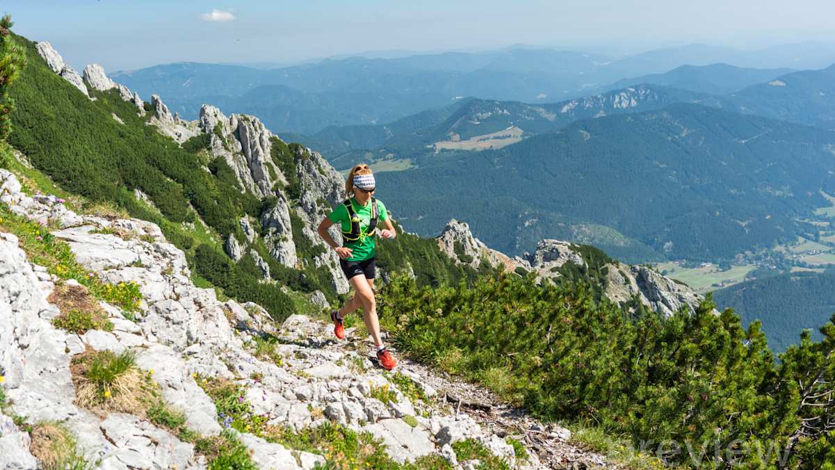 Trailläuferin am Nandlgrat am Schneeberg, Ausblick auf die umliegende Hügel- und Berglandschaft