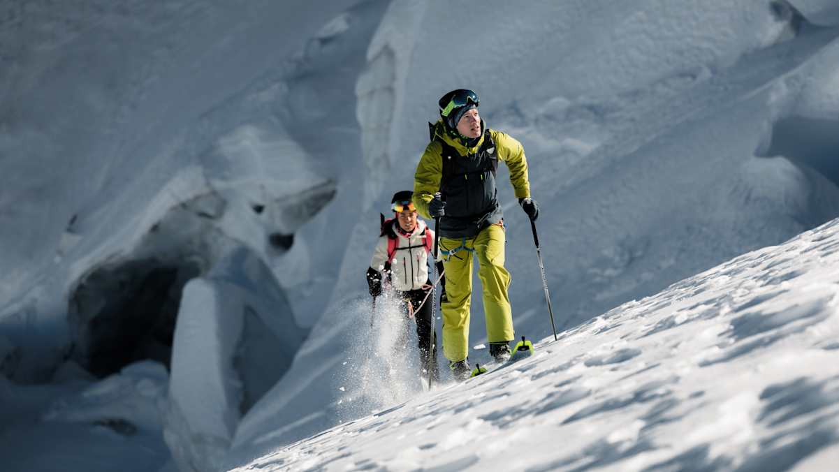 Skitourengeher mit Dynafit Blacklight-Ausrüstung beim Aufstieg durch tiefen Schnee im Gebirge.