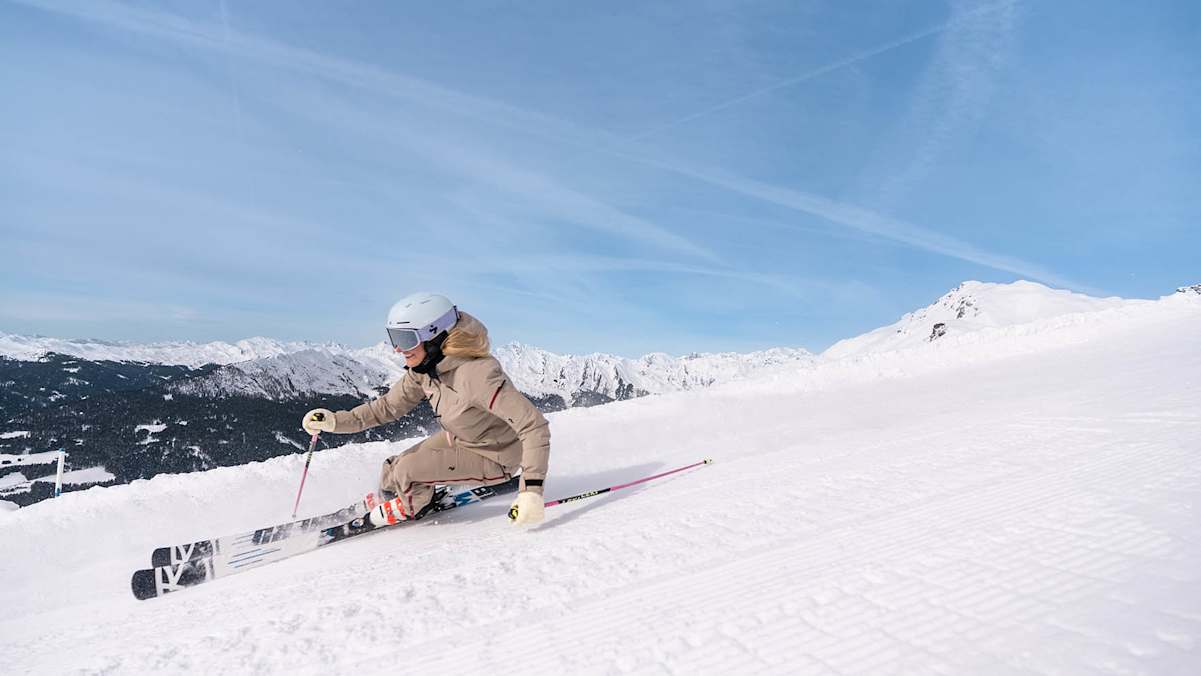 Frau beim Skifahren in Südtirol auf perfekter Piste mit Panoramablick.