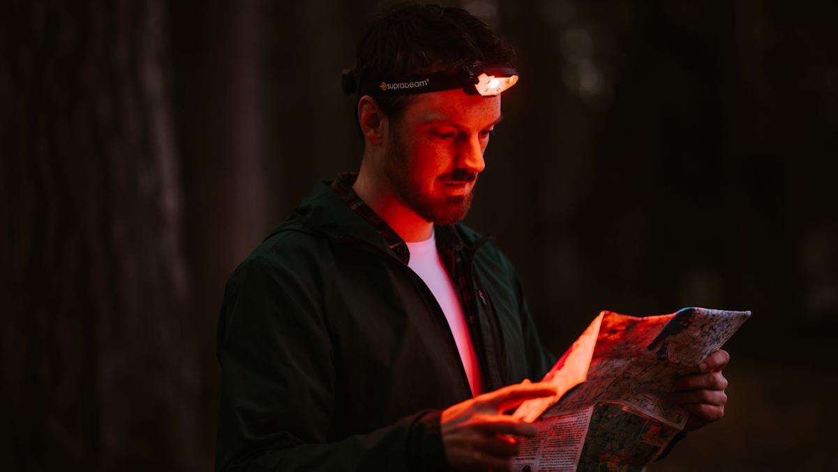 Wanderer beim Lesen einer Karte mit dem Rotlichtmodus der Suprabeam V7