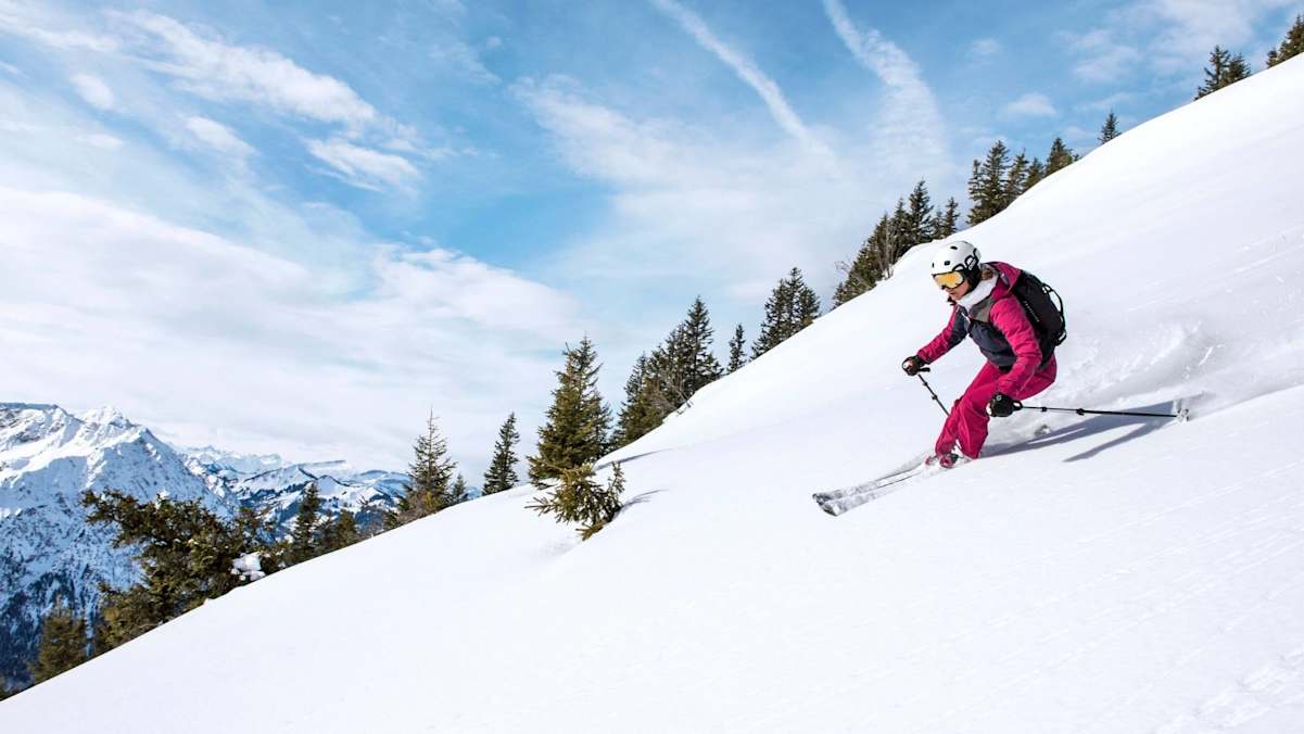 Eine Tourengeherin genießt die Schwünge bei der Abfahrt
